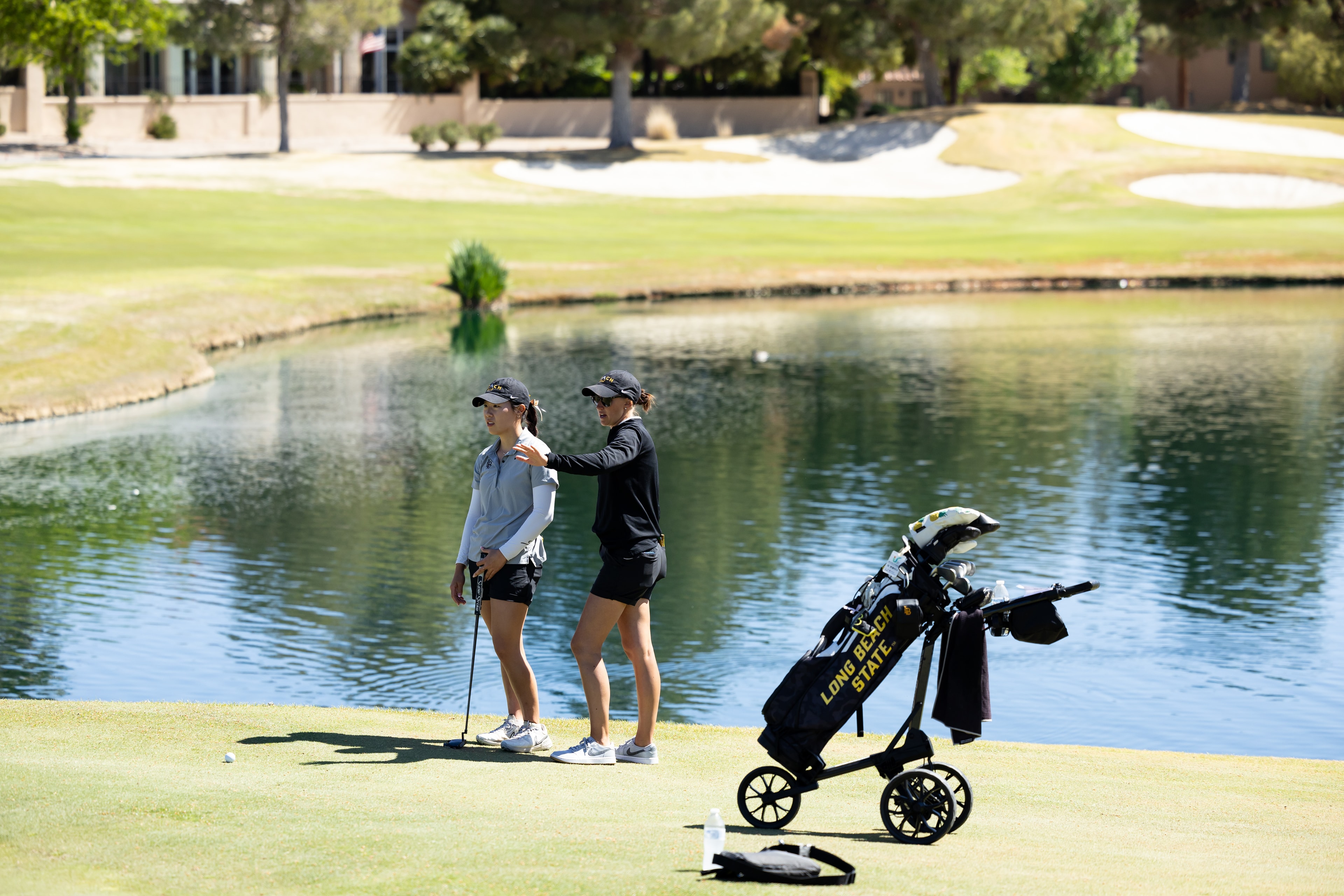 Two golfers playing a lakeside course